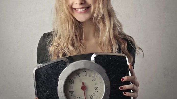 Jeune femme satisfaite de sa balance